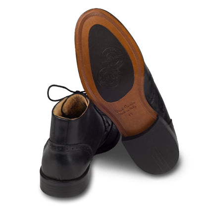 Exton Herren Budapester Stiefelette in schwarz, knöchelhoch. Aus hochwertigem Kalbsleder handgefertigt. Ansicht der Ferse und Sohlenunterseite.